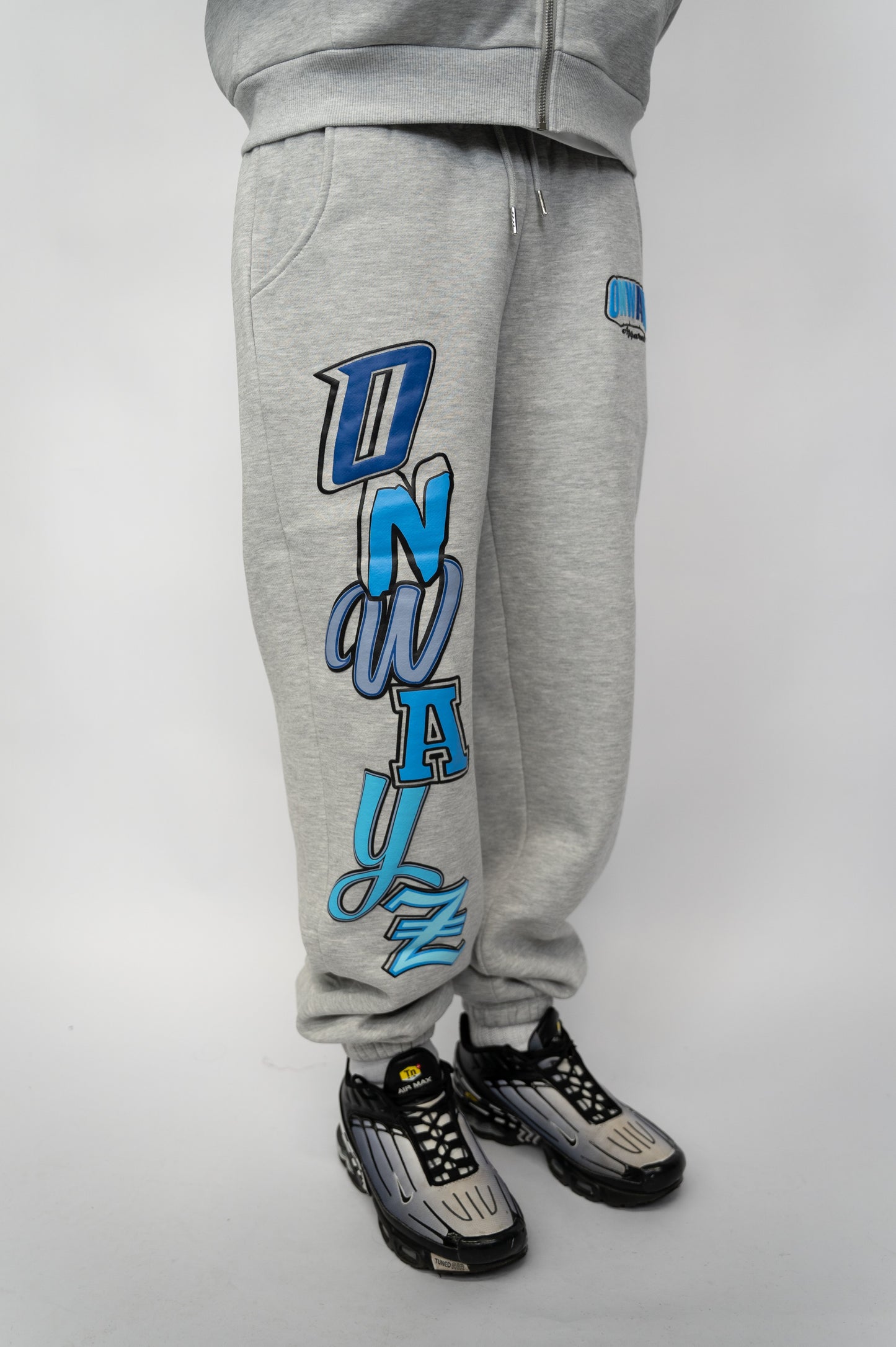 Gray sweatpants with blue text and graphics on a gray background